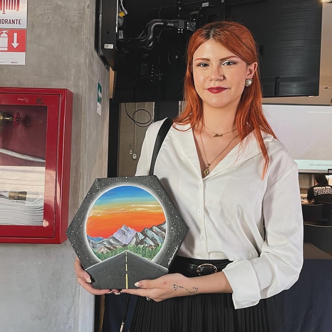 La artista Ana Madrid entregando su obra de arte titulada “Road to Space...